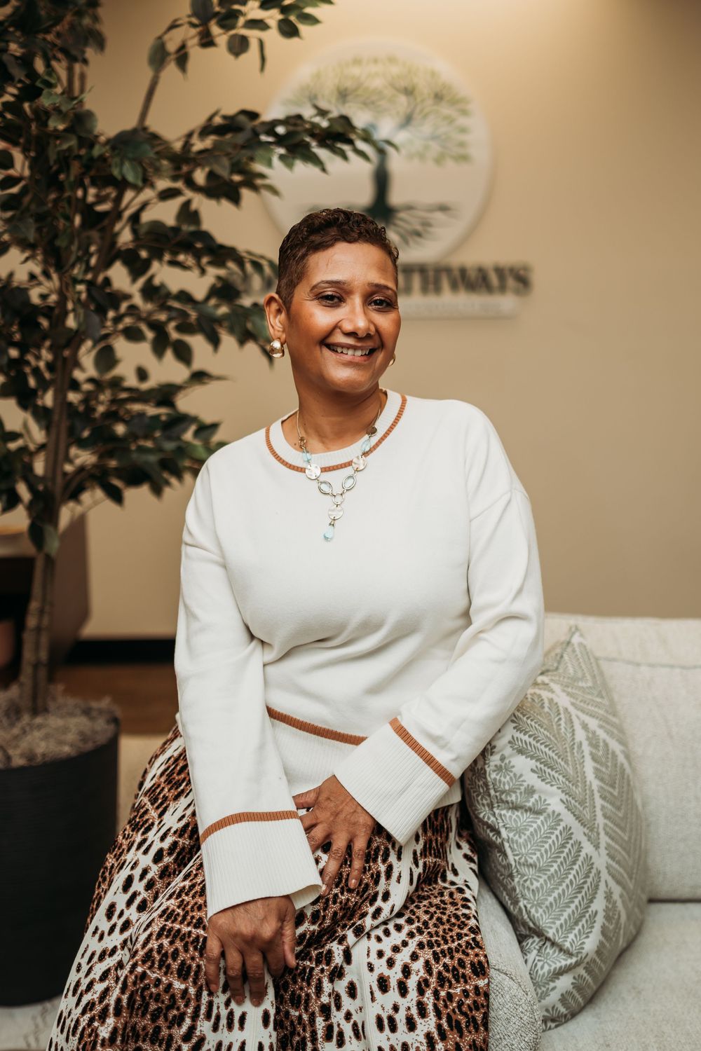 Stylish portrait featuring a white sweater and leopard print skirt in an office.
