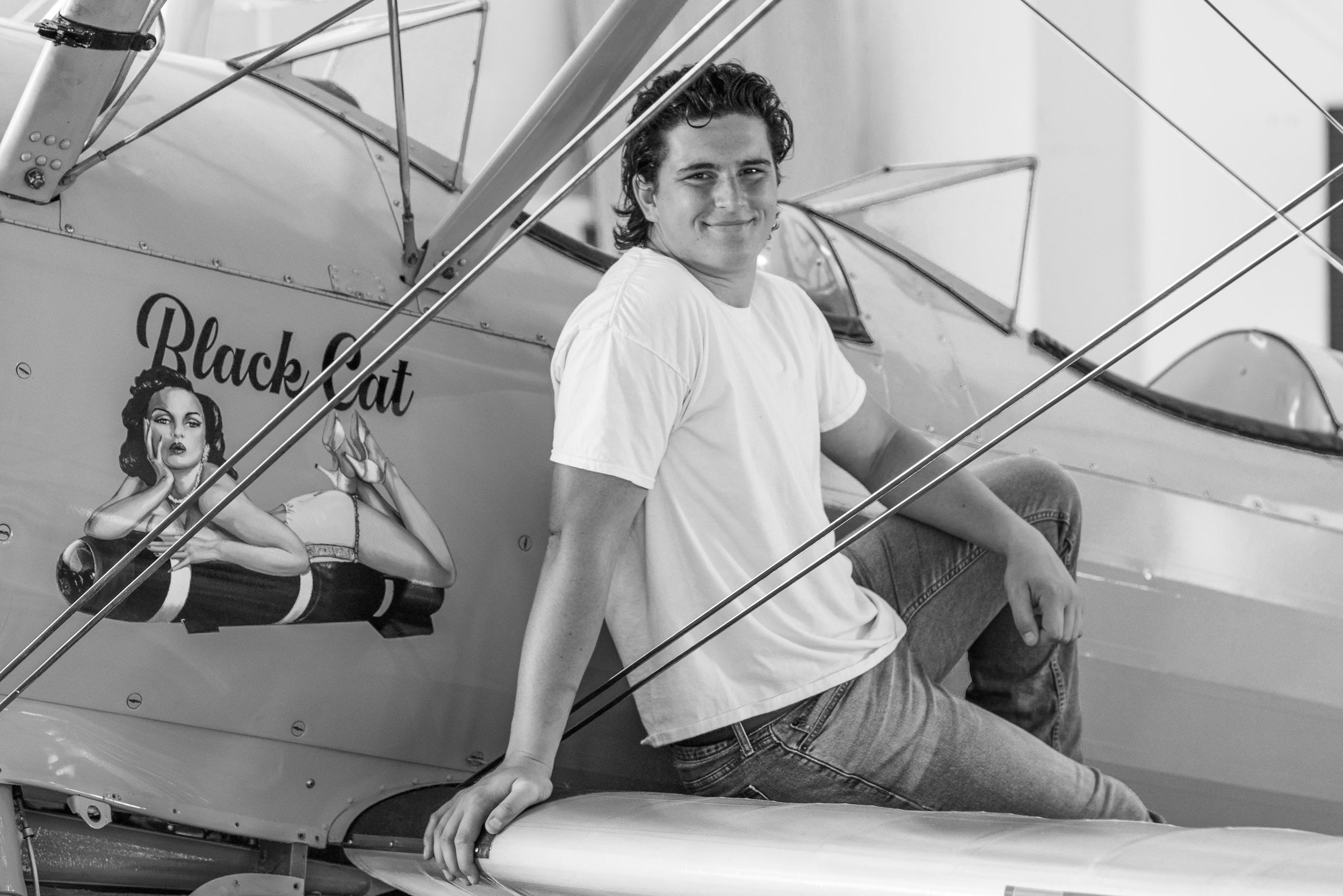 Black and white photos of someone posing with vintage aircraft in various playful poses.