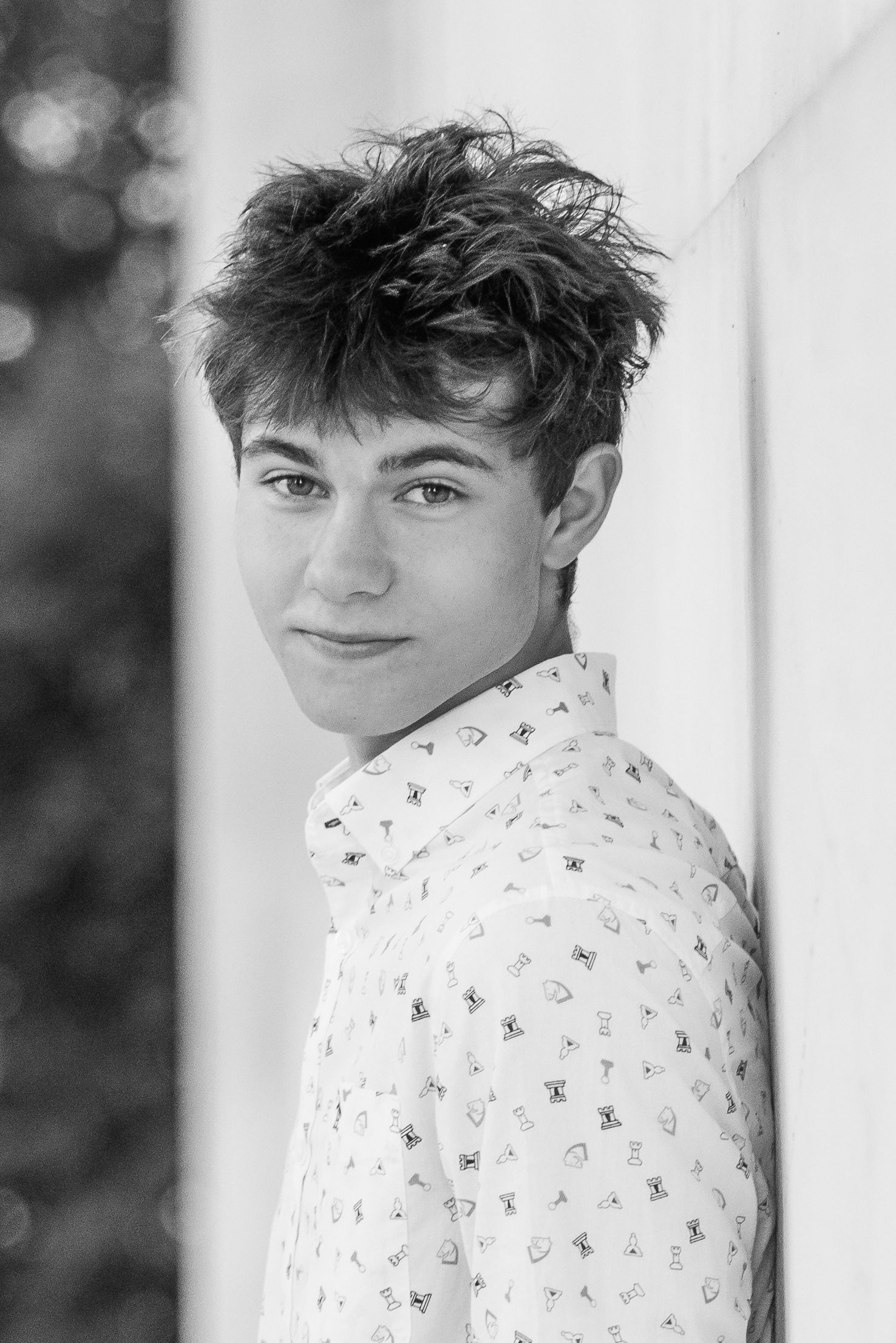 Black and white portrait series showing someone wearing a patterned shirt against a light background.