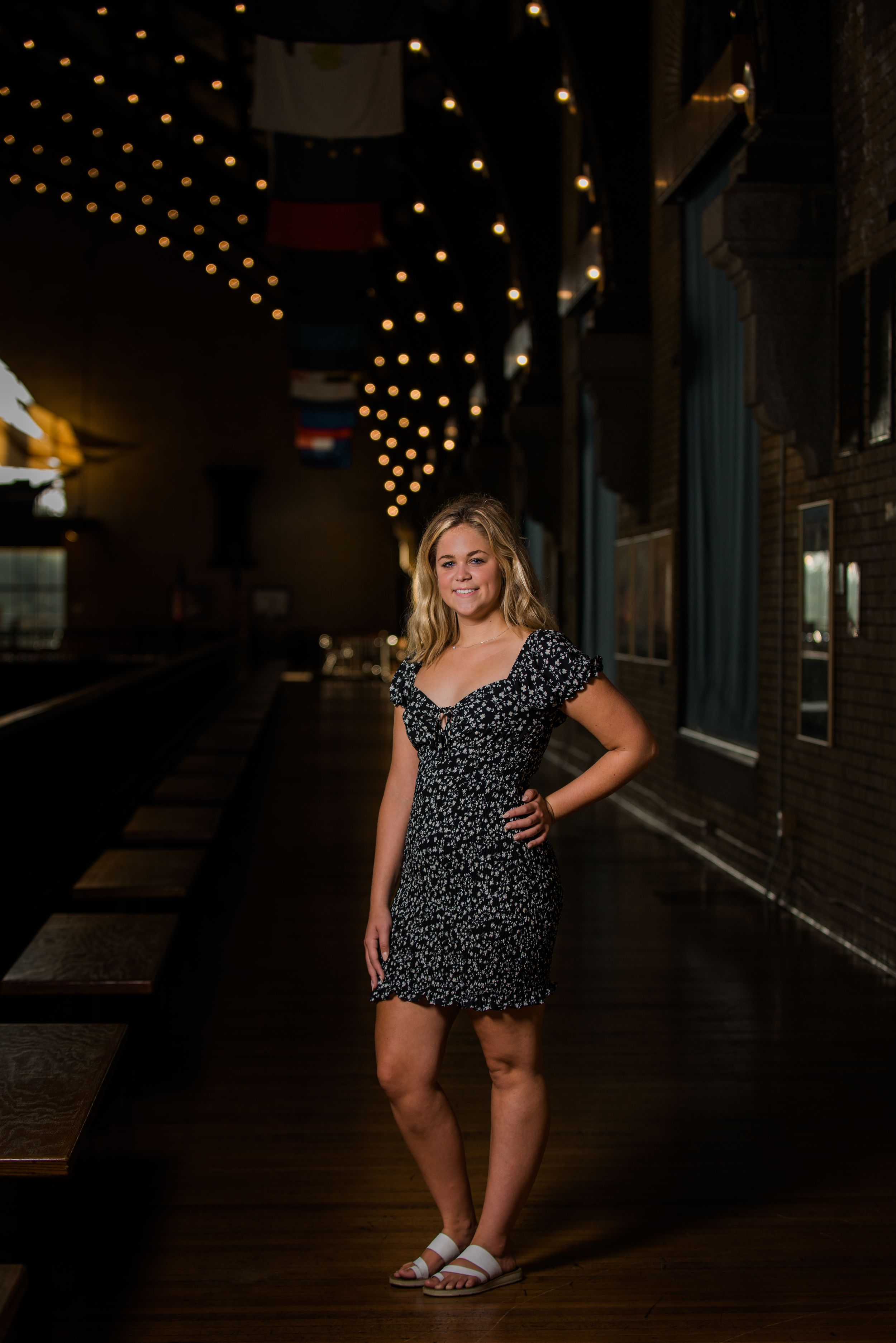Night portrait series under string lights creating a moody urban atmosphere.