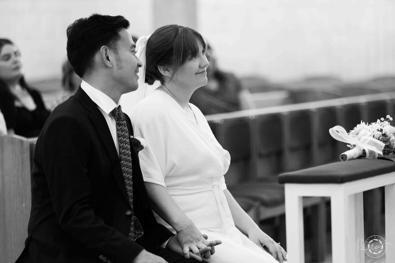 A black and white photo capturing a couple during their wedding ceremony.