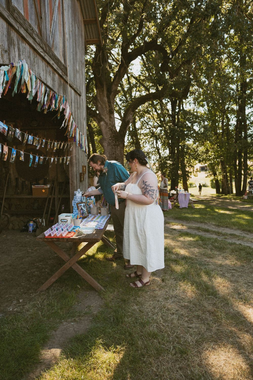 A vintage barn decorated with colorful bunting and string lights creates a charming outdoor party setting.