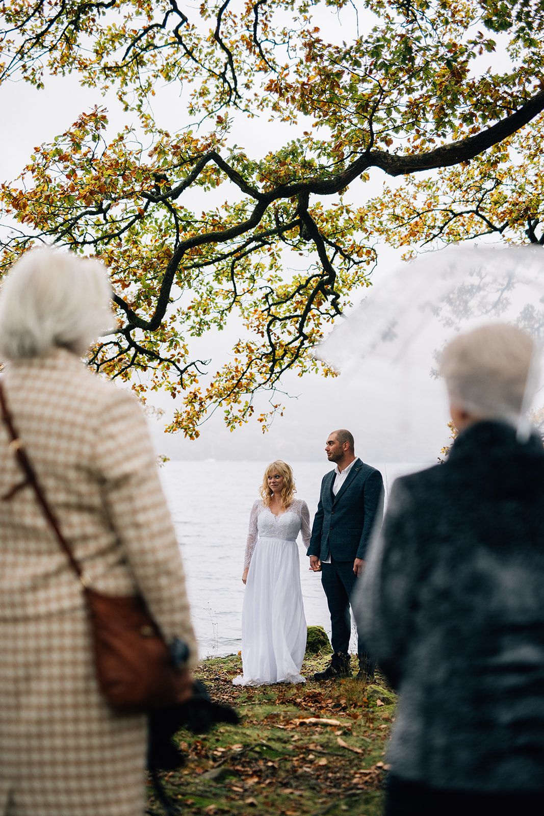 A romantic black and white photo series shows a couple embracing in a floral dress and suit against rolling hills.
