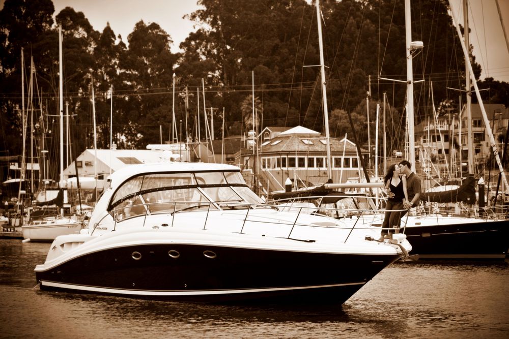 A panoramic view of boats and yachts docked at a marina with trees lining the shoreline.
