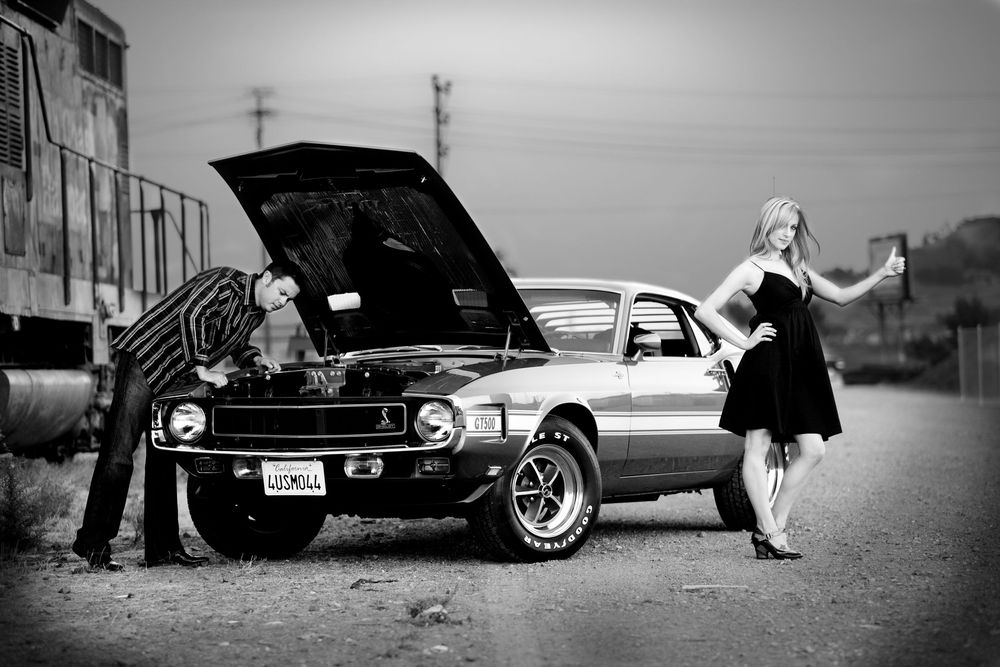 Classic vintage cars parked on a street in black and white photography.
