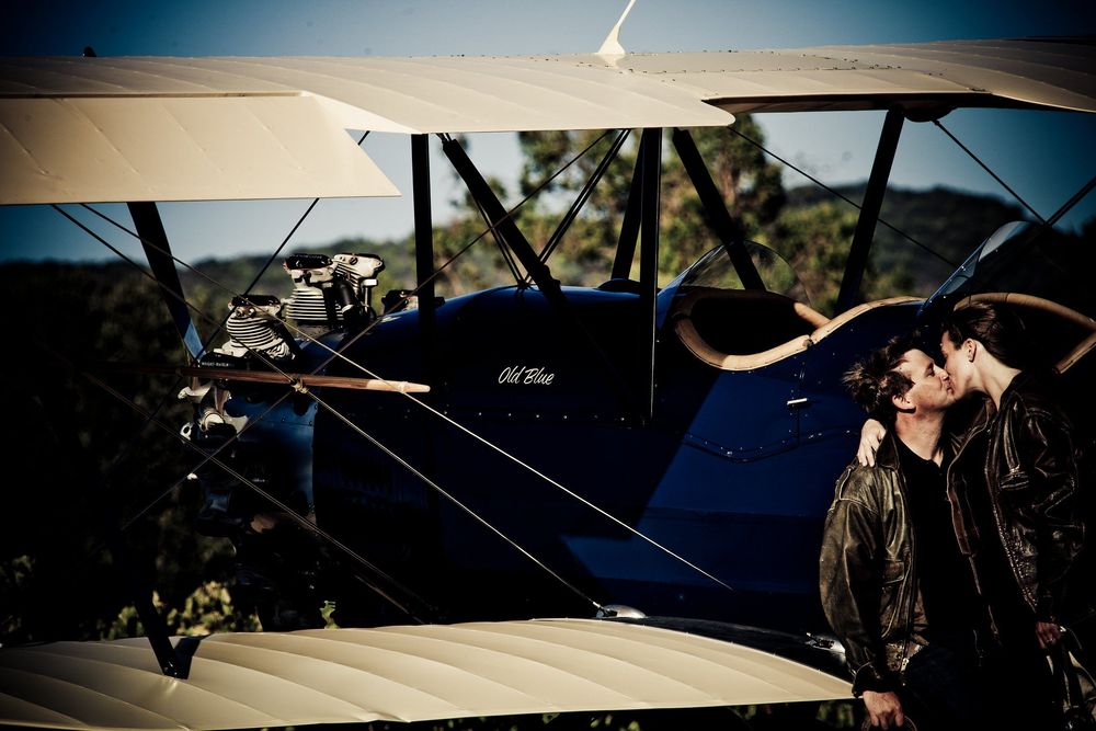 Vintage aircraft and aviation equipment silhouetted against a dramatic sunset sky.