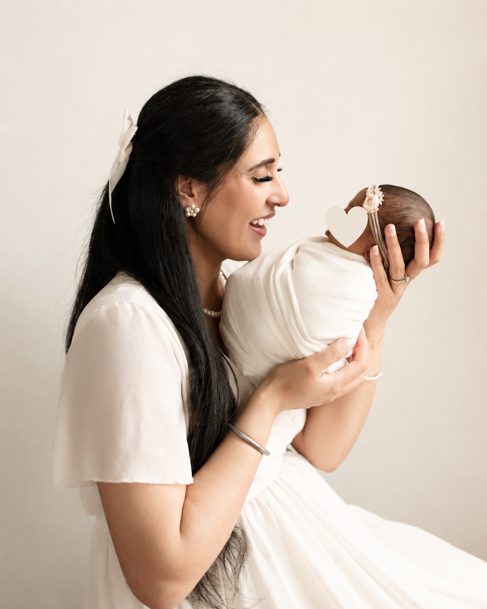 Mother holding her newborn during an in-home newborn photography session in Osoyoos, BC, captured in a soft and timeless style