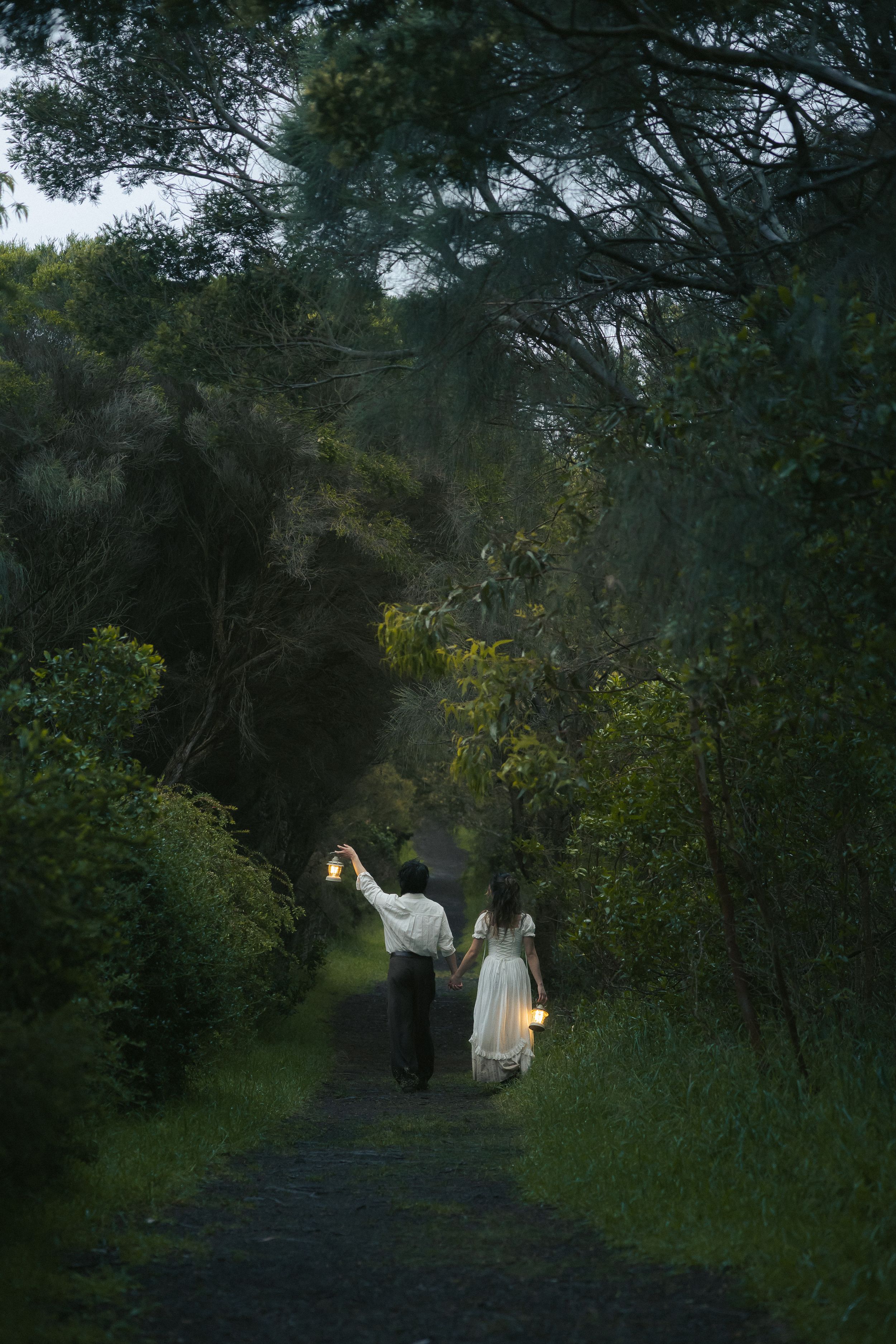 Couple walking through tree-covered path during Mornington Peninsula pre-wedding session