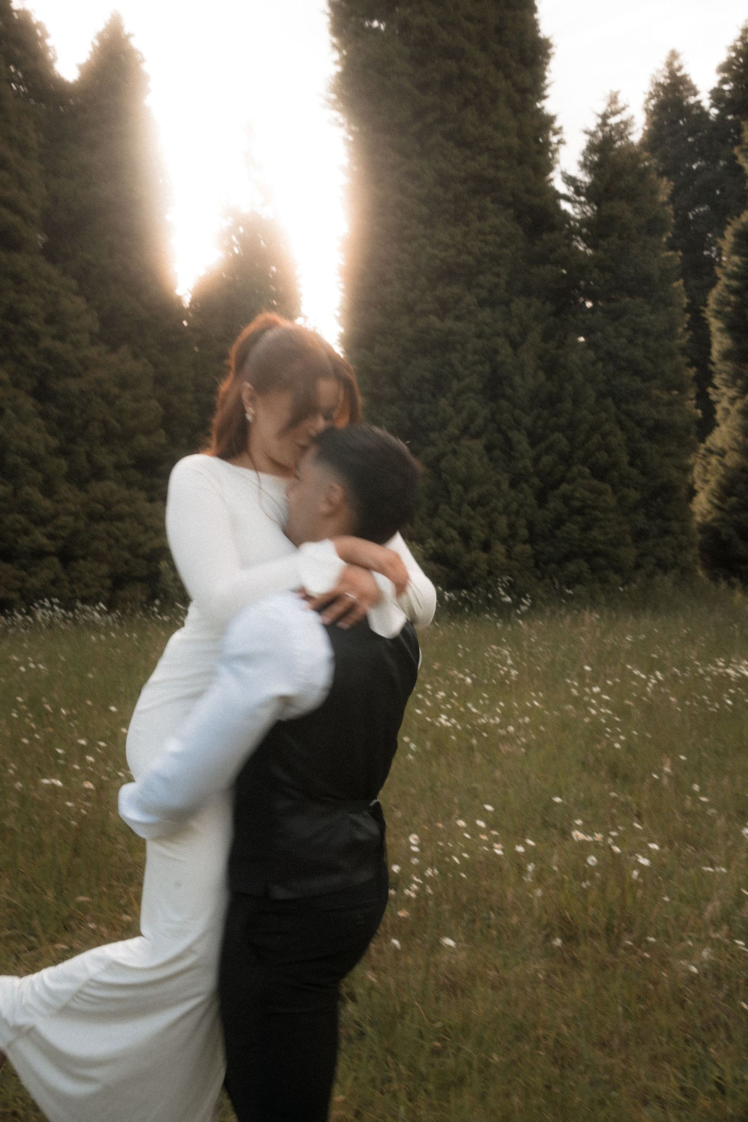 A romantic dance sequence in a meadow with sunlit pine trees behind.