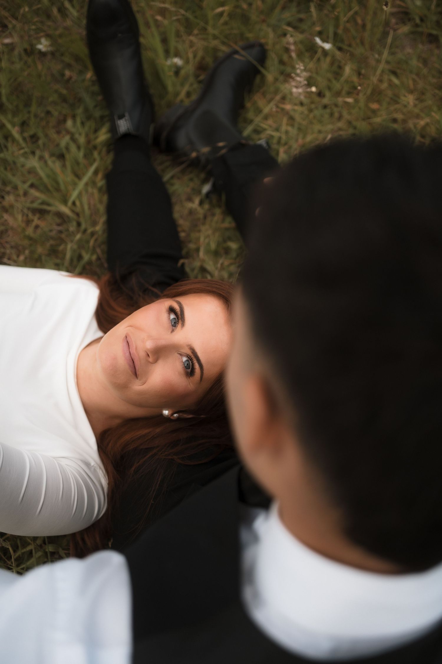 Artistic black and white portrait shot in grass showing romantic composition.