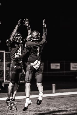Black and white photo sequence shows two football players celebrating and running together on the sideline.