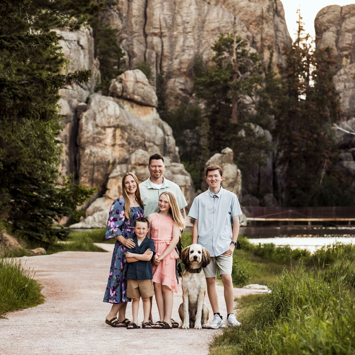 Group photo session near large rock formations in a scenic outdoor setting.