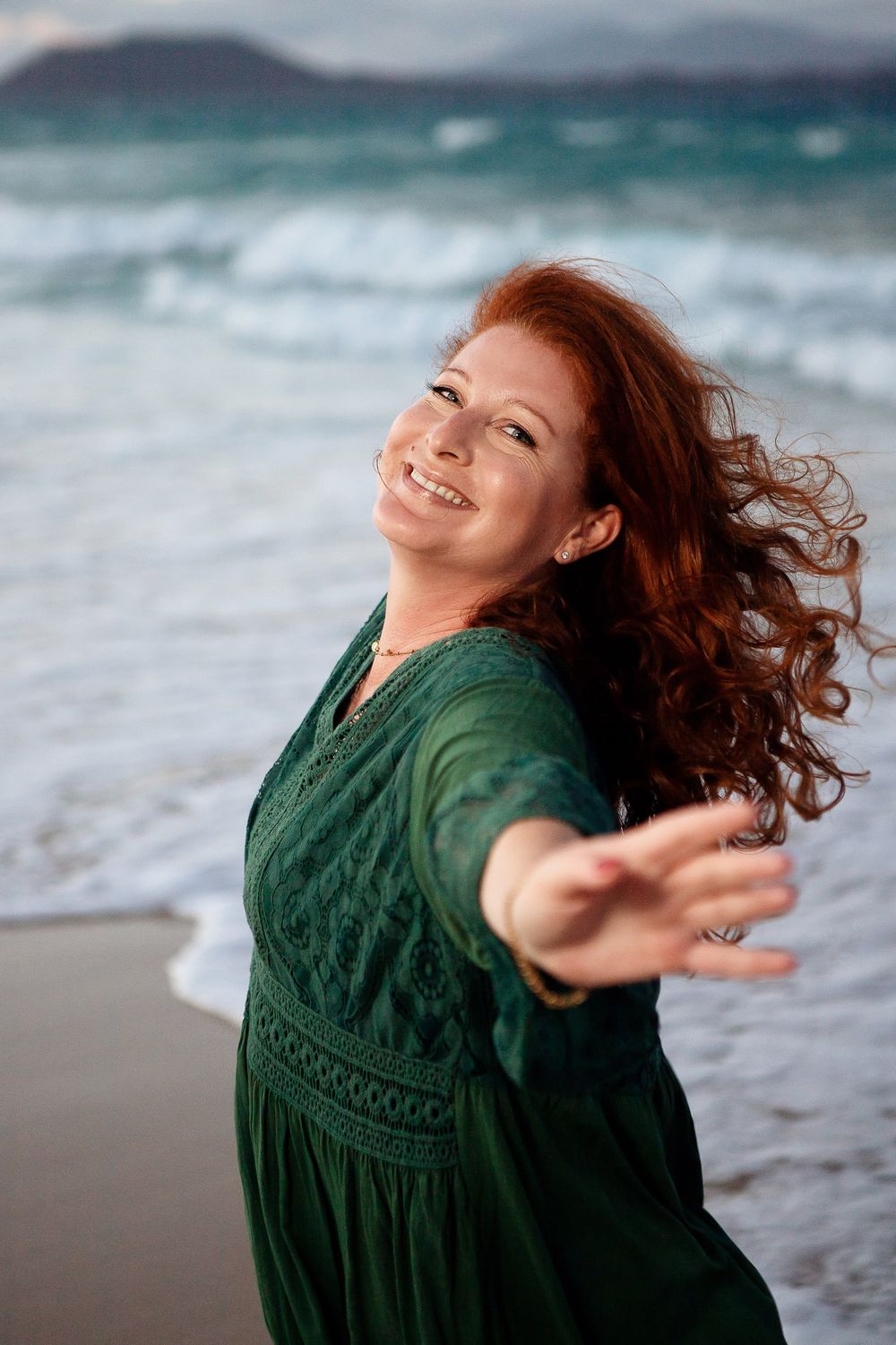 Happy woman with curly hair on the shore of Grandes Playas - Natural lifestyle photography in Corralejo