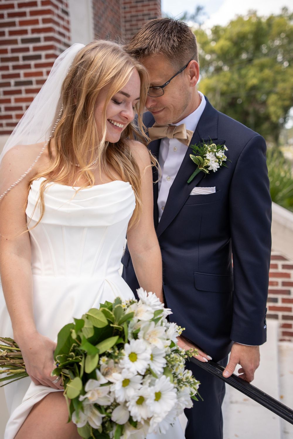A bride and groom share intimate moments in a series of romantic wedding photos against a brick wall backdrop.