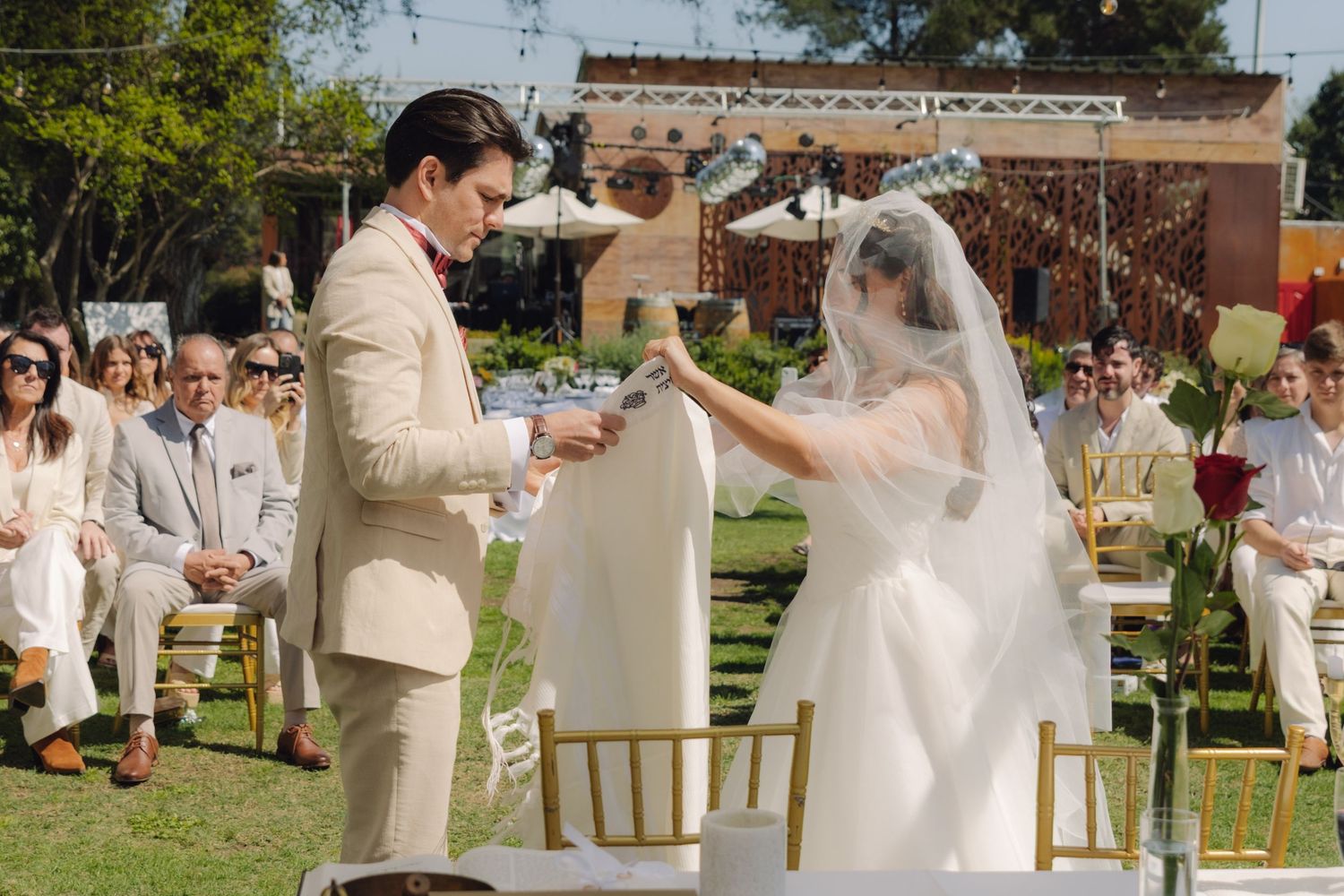 Bride and groom exchange vows during elegant outdoor garden wedding ceremony.