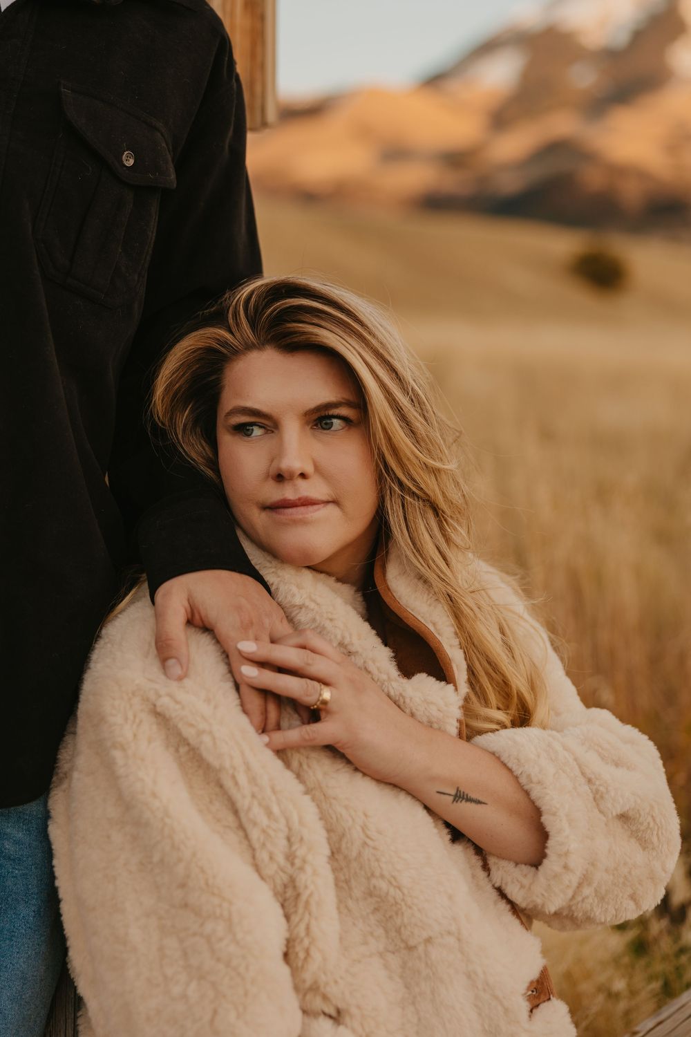 Montana Wedding photographer captures engagement photos of couple leaning into each other in their elegant western attire. Near Sage Lodge