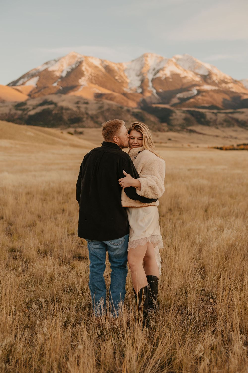 Western couple embraces under the mountains in Paradise valley for their engagement photos captured by Montana Photographer in Pray, Montana