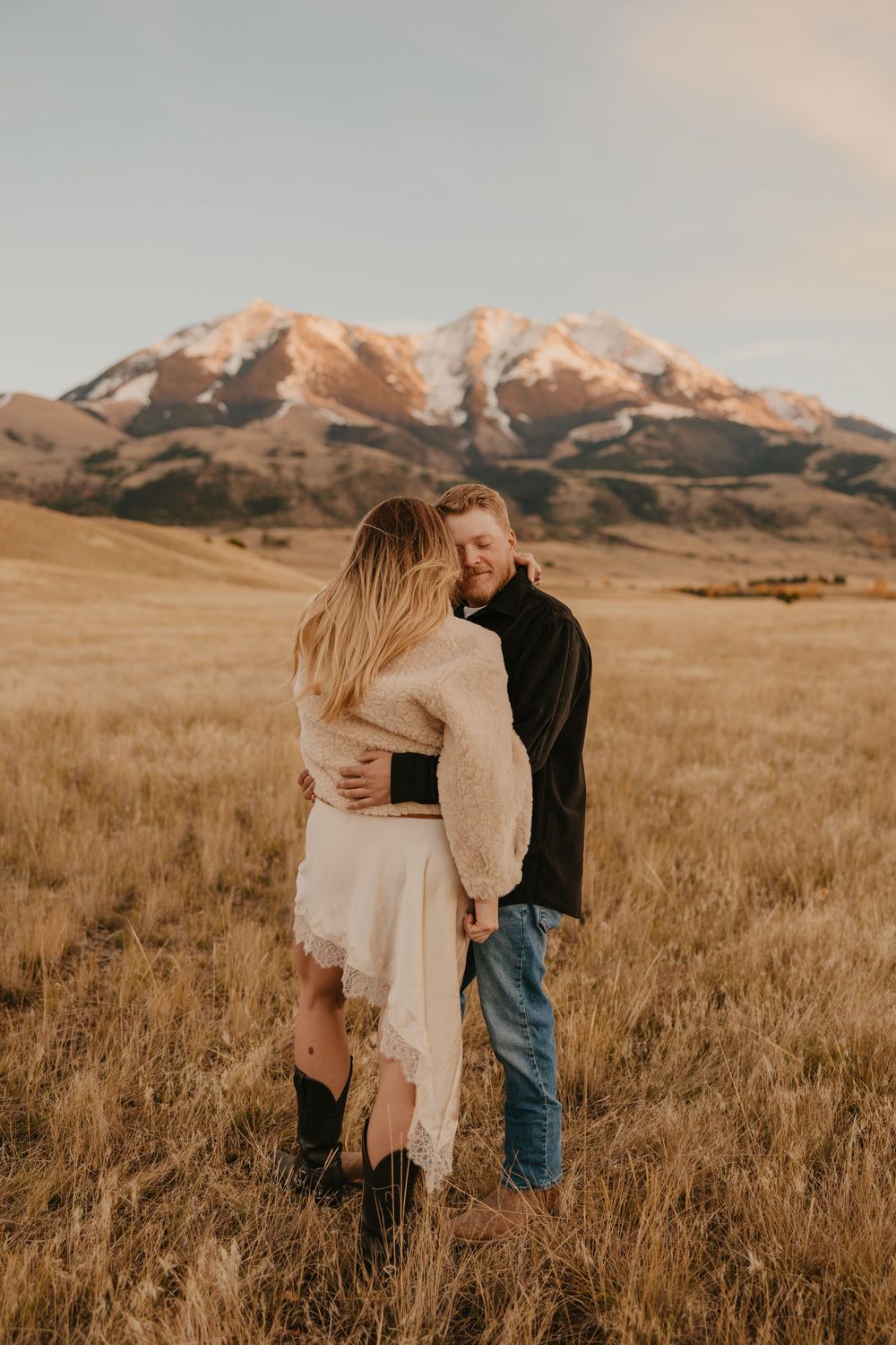 Western couple embraces under the mountains in Paradise valley for their engagement photos captured by Montana Photographer in Pray, Montana