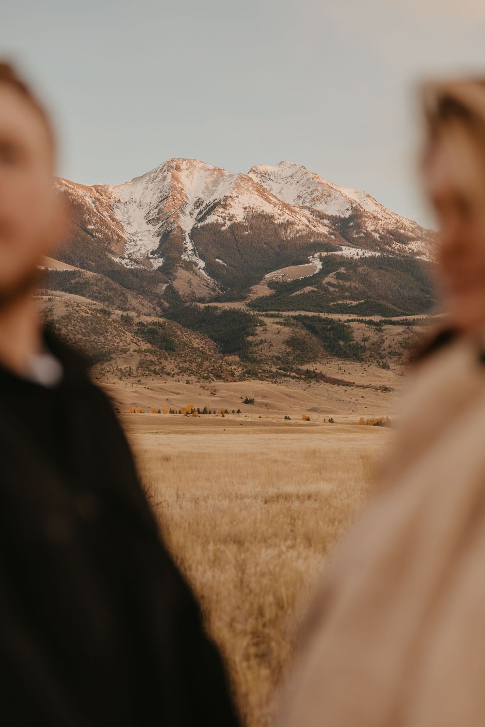 Western couple embraces under the mountains in Paradise valley for their engagement photos captured by Montana Photographer in Pray, Montana