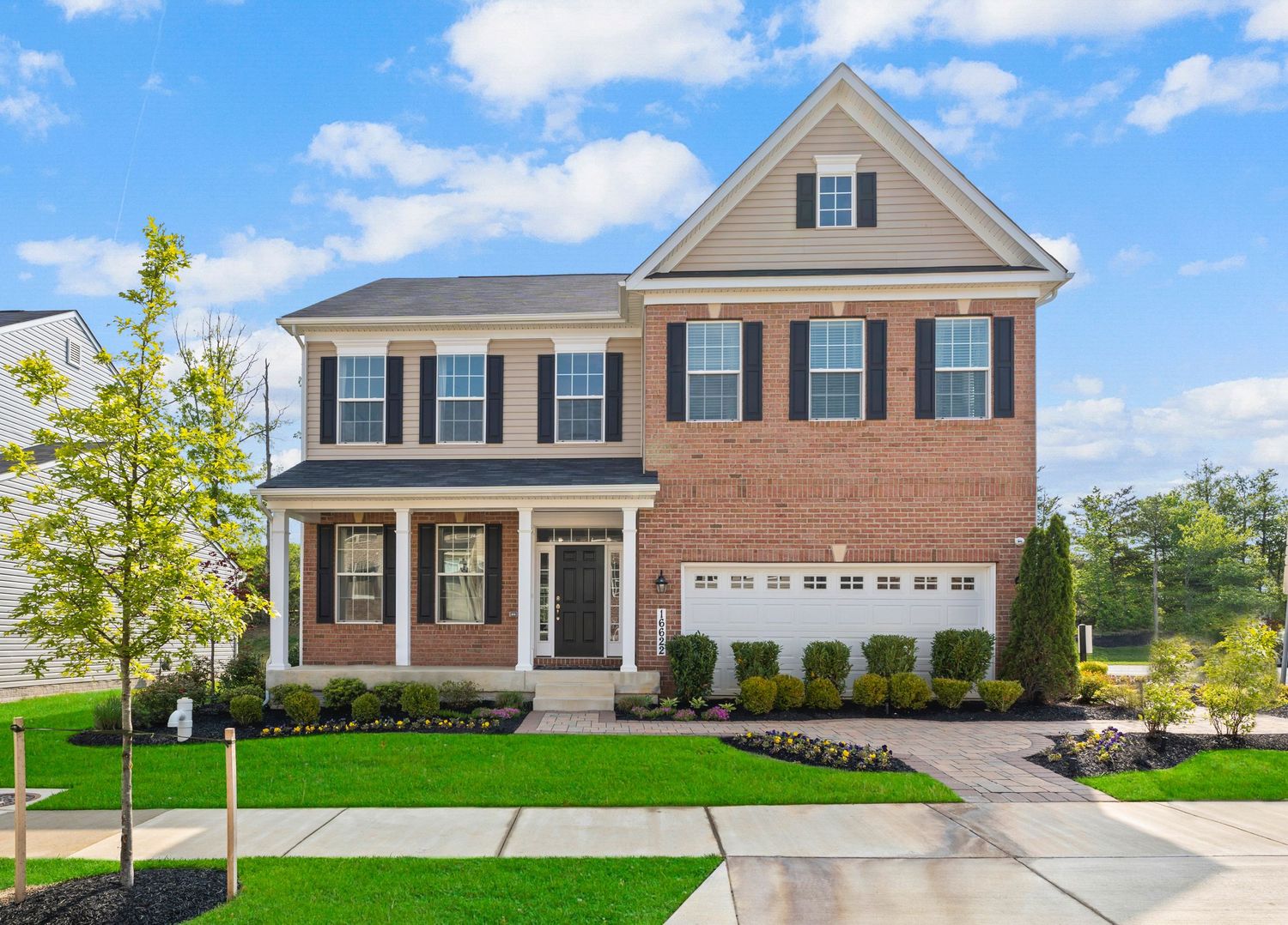 Front exterior views of upscale suburban homes with manicured lawns and driveways.