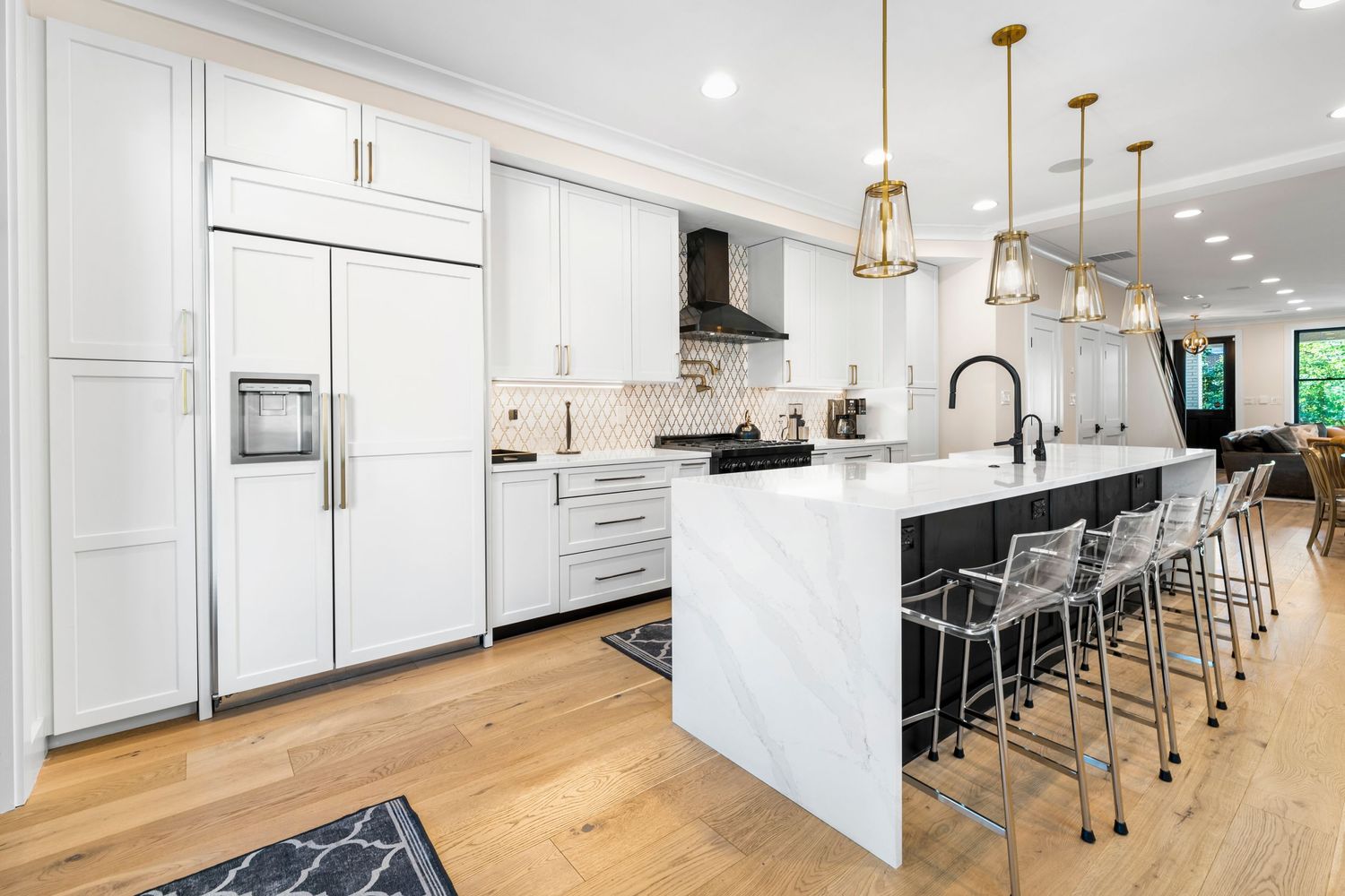 Spacious white kitchen with geometric patterned runner and modern gold pendant lights.