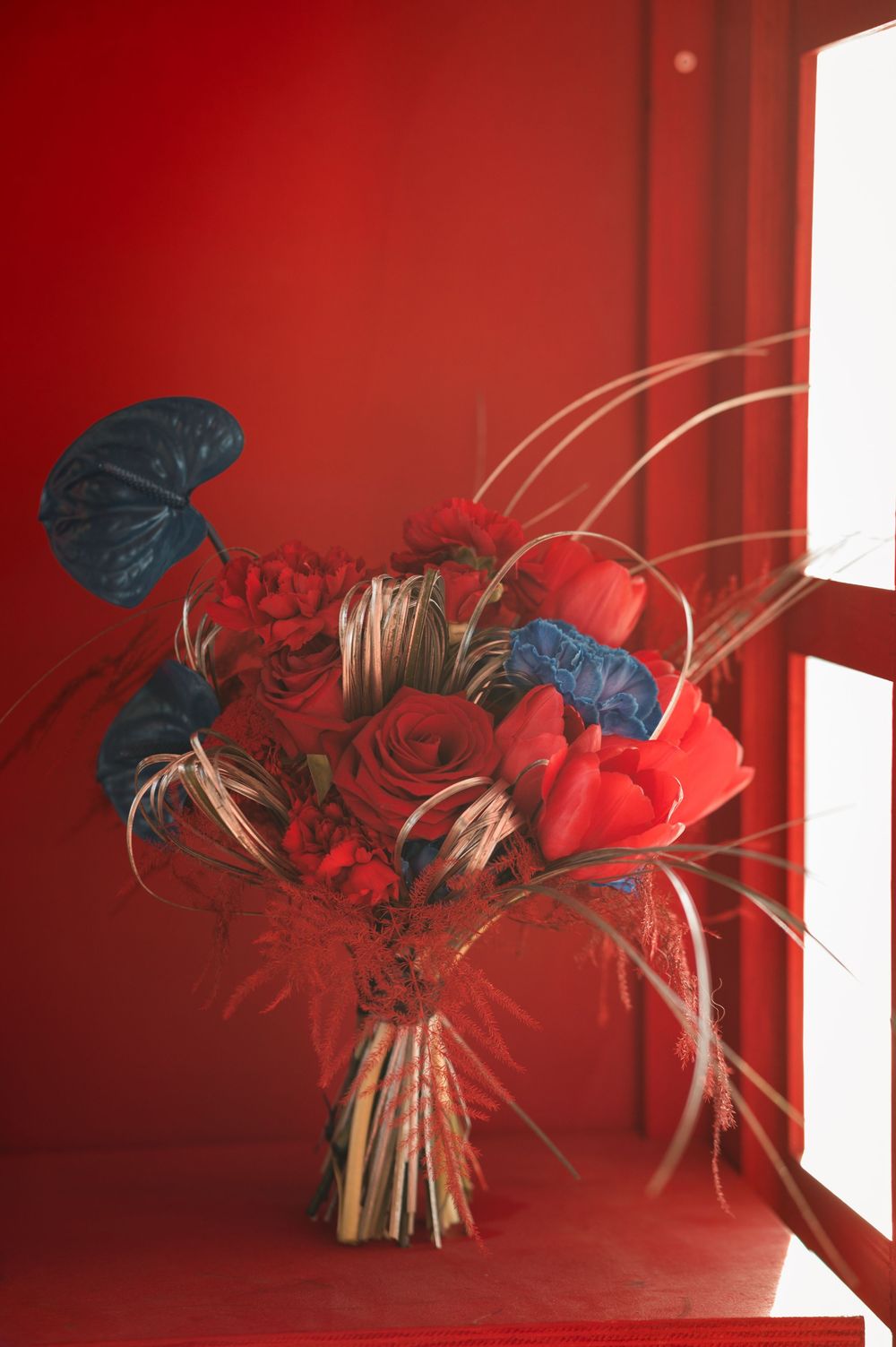Bouquet de la mariée bleu et rouge de Fleurs Menth à l'eau pour le shooting Brit Pop à  Vœgtlinshoffen en Alsace