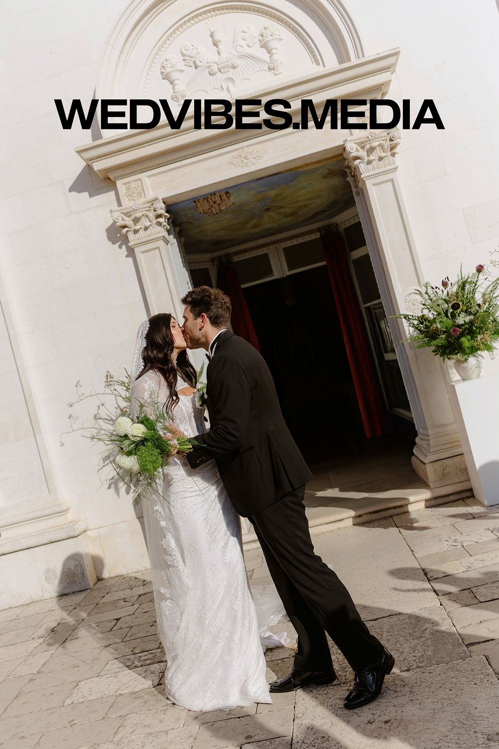 Wedding couple shares intimate moment in elegant white stone archway during romantic photo session Wedvibes media, Hvar, Croatia