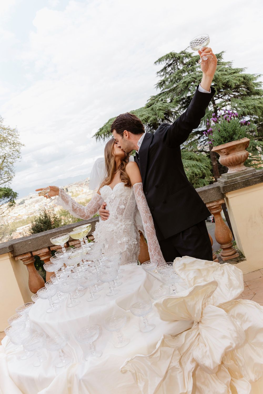 A romantic wedding couple dances and dips on a stone terrace surrounded by greenery in a series of flowing movements , Villa Aurelia, Rome