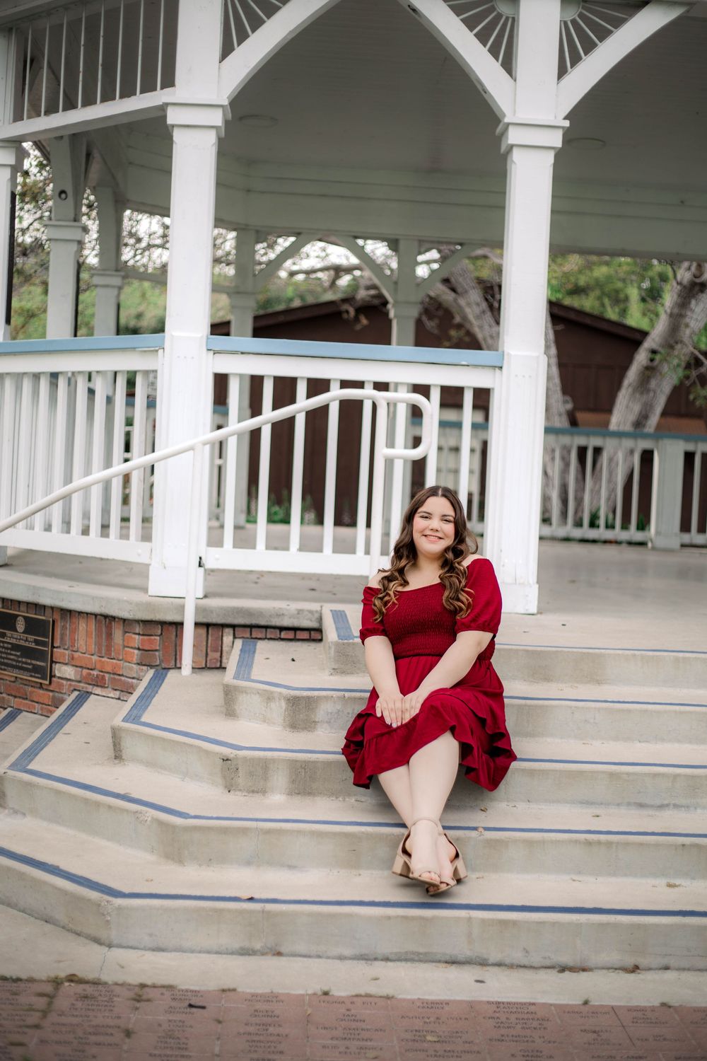 A series of portrait shots taken on white gazebo steps featuring someone in a red dress sitting in different poses.