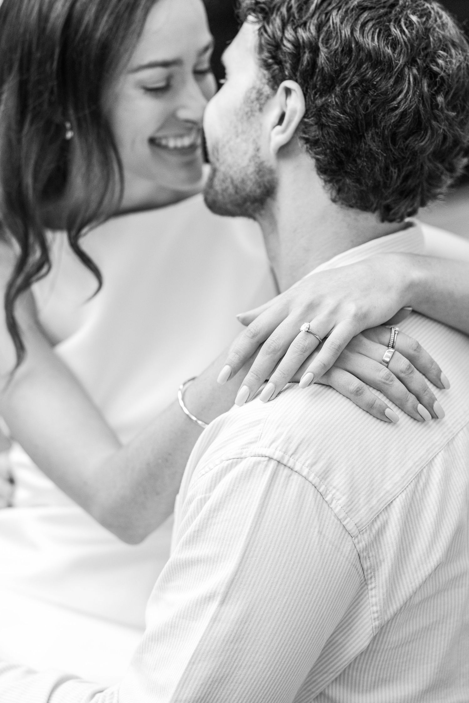 Black and white romantic photo sequence showing a couple embracing in tender moments with hands displaying wedding rings.