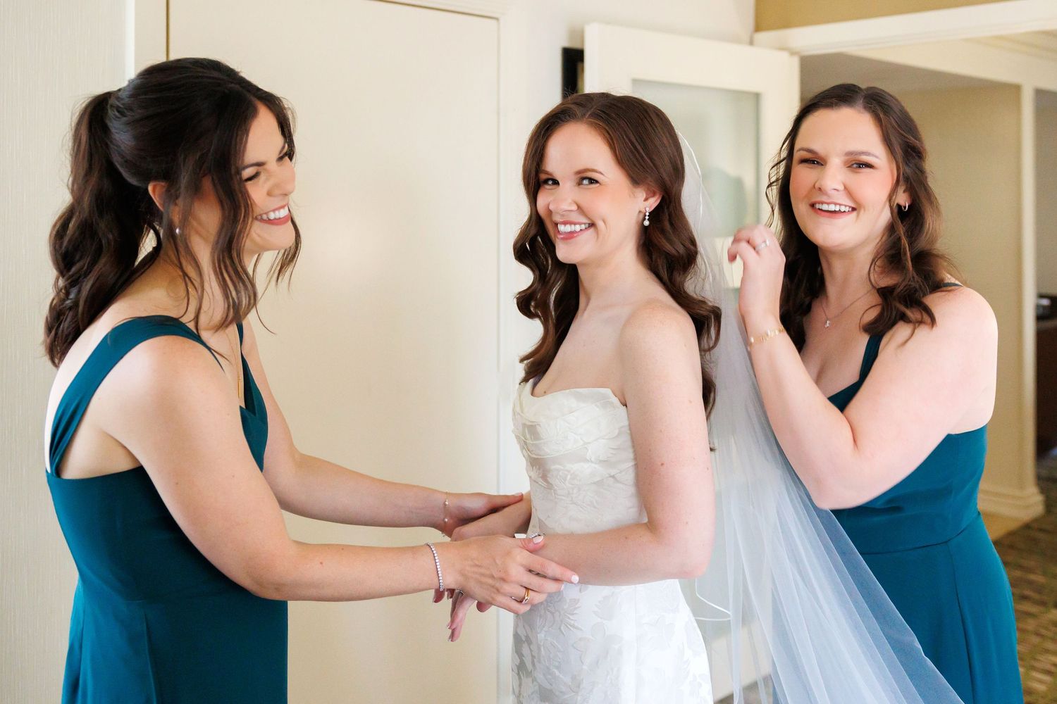 Sisters putting veil on bride at Cleveland wedding.