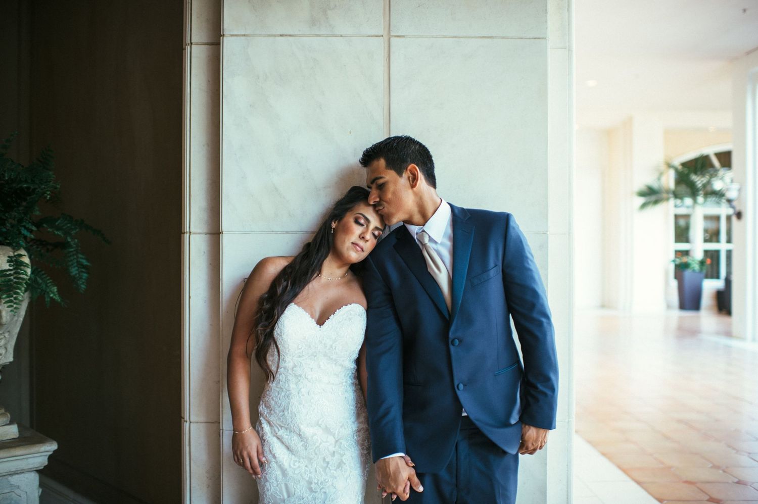 Intimate wedding portraits captured in a bright, minimalist indoor setting.