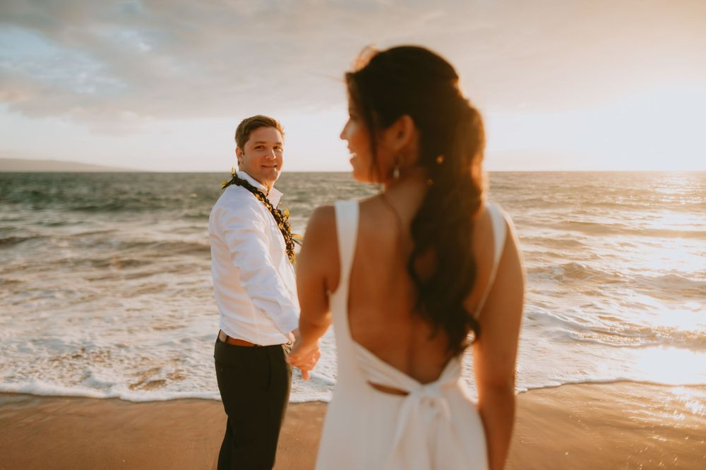 Sunset beach wedding photography with golden light illuminating the couple.