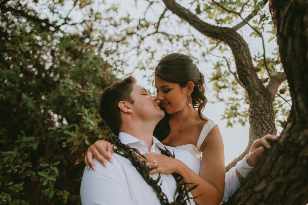 Intimate wedding portraits captured under tropical trees at sunset.