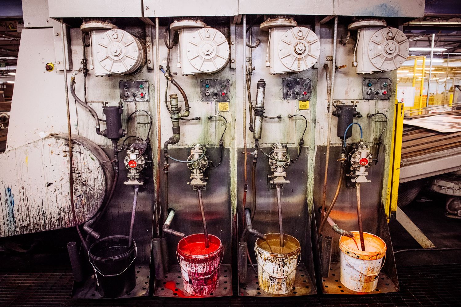 Industrial ink dispensing system with multiple taps and containers in a row.