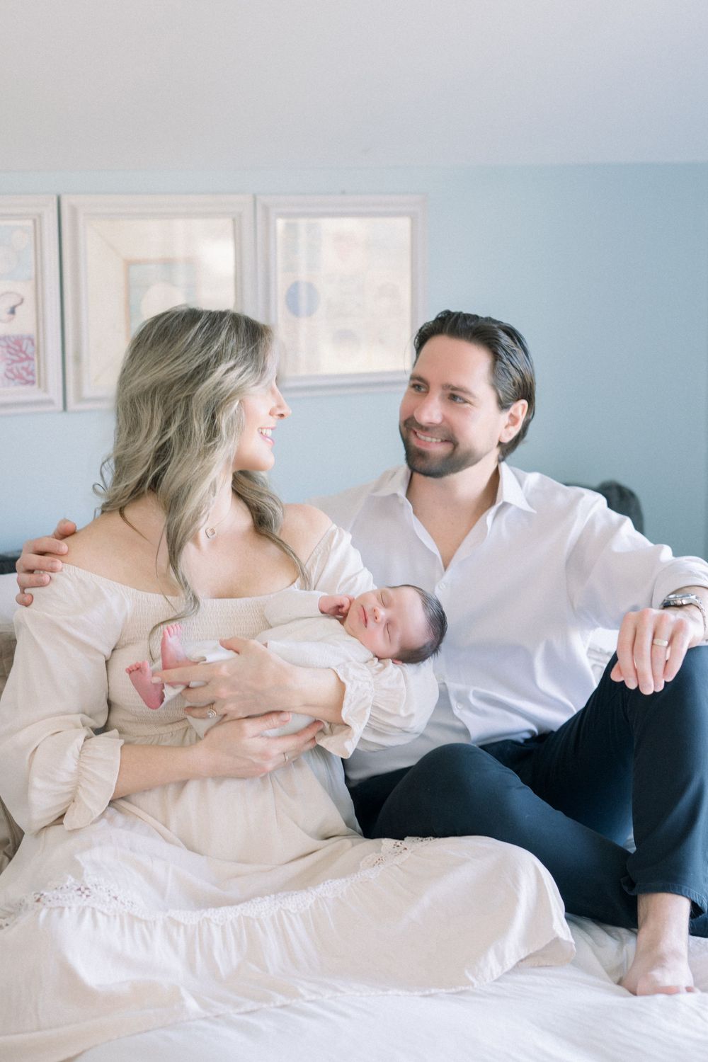 A  family moment captured in soft, light tones as parents share intimate time with their newborn by a washington dc newborn photographer