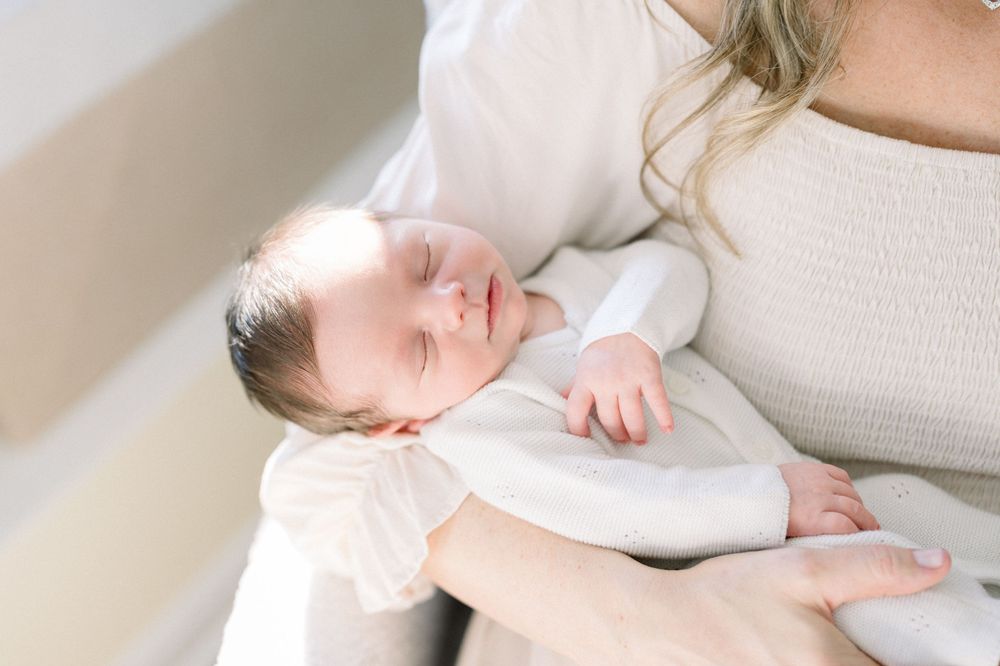 Baby in white onesie sleeping peacefully at a washington dc newborn photo session