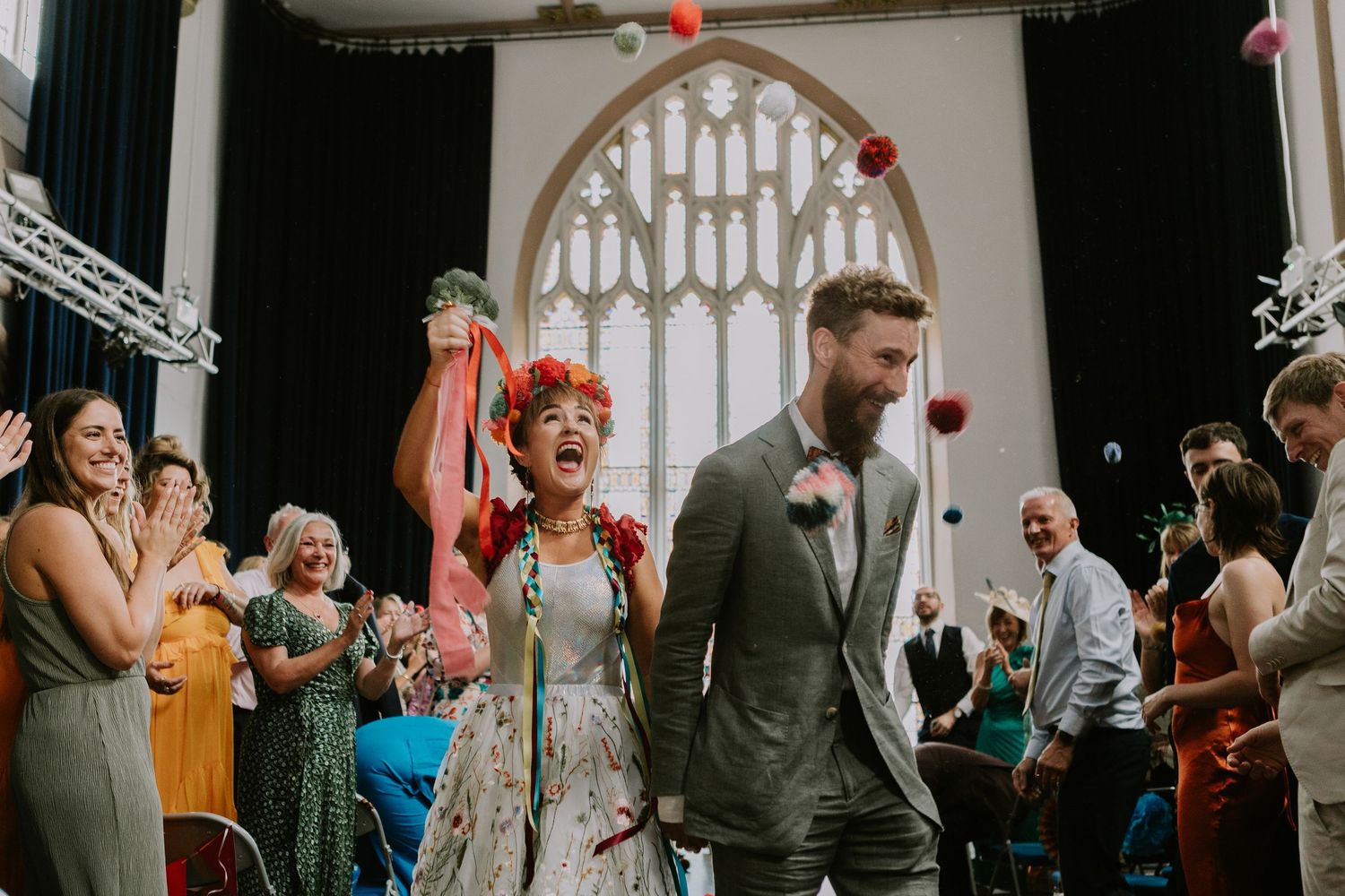Wedding guests dance and celebrate on the dance floor during a joyful reception celebration.