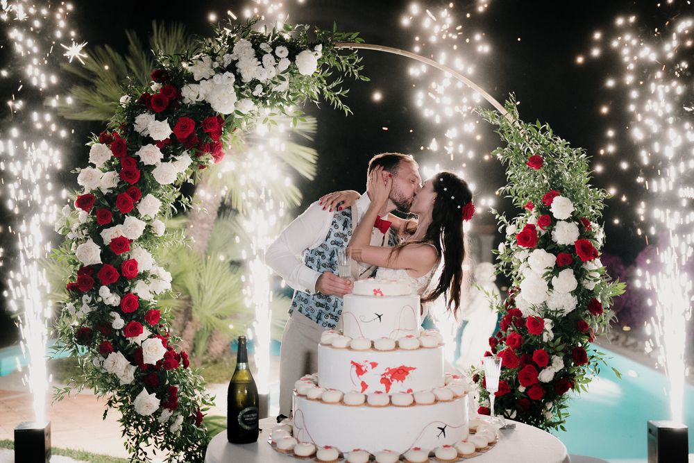Bacio degli sposi durante taglio torta con fuochi d’artificio a Villa Casa Rossa Imperia