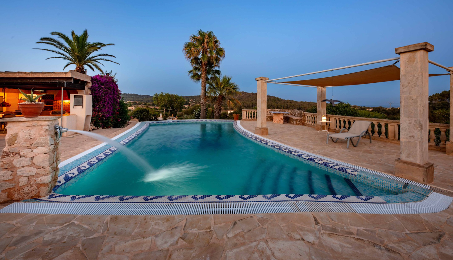 Stunning coastal villa development overlooking Mediterranean Sea during golden sunset with mountains in background.