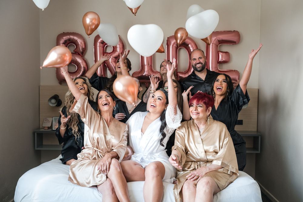 Bride celebrating with bridesmaids during wedding preparation