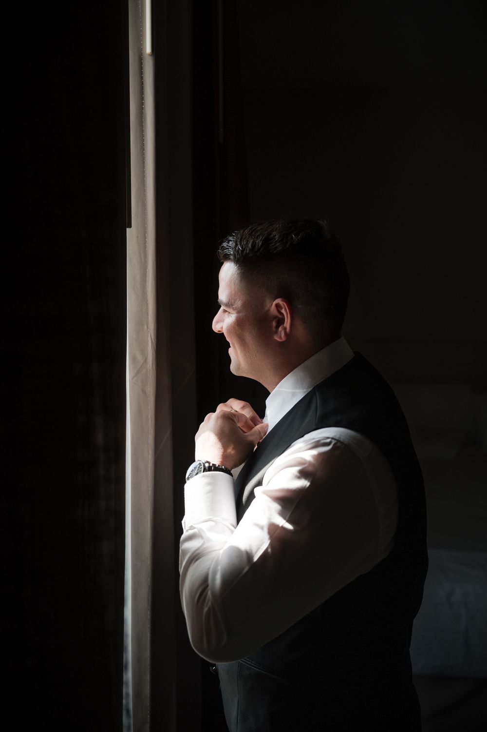 Groom portrait in low light during wedding preparation