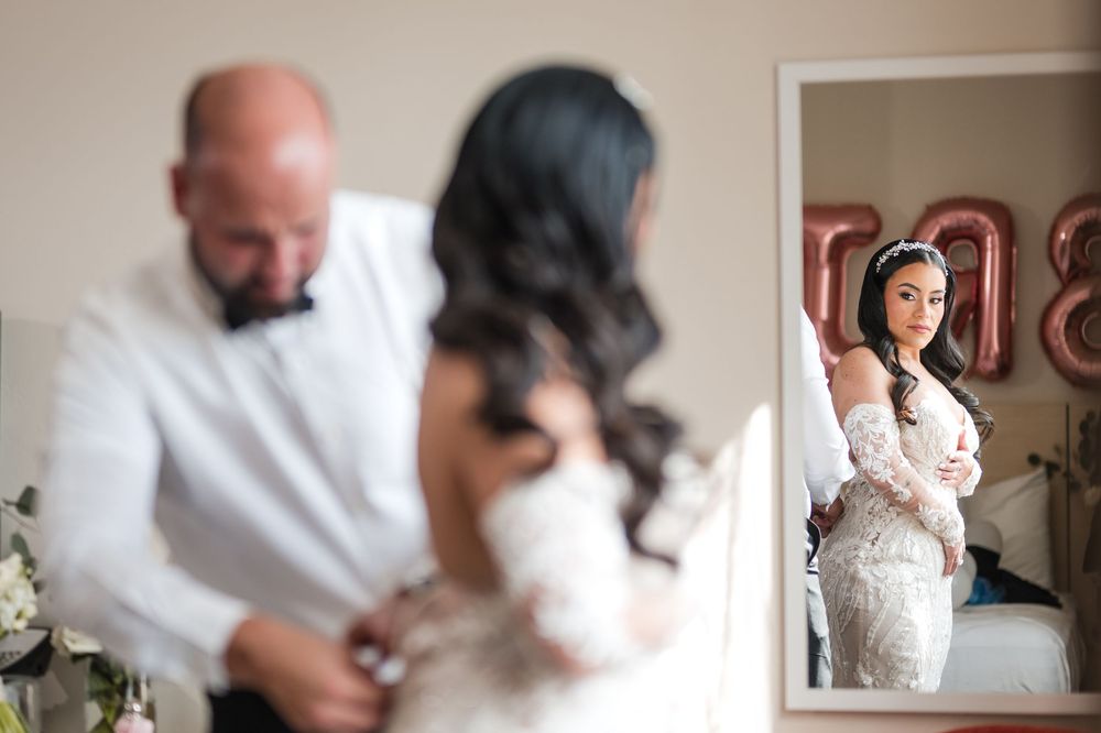 Bride getting ready with help during wedding day preparation