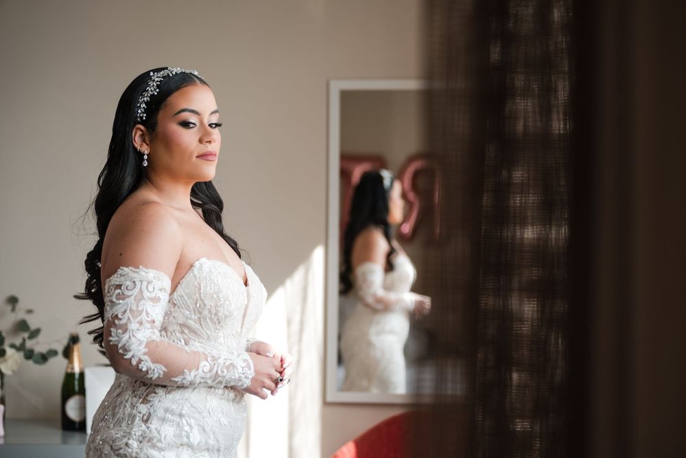 Bride looking at reflection in mirror during wedding preparation in Puerto Rico