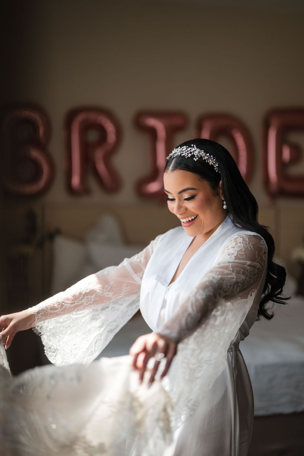 Bride adjusting dress near window during preparation