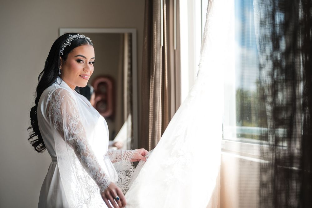 Bride looking out window during wedding preparation with natural light
