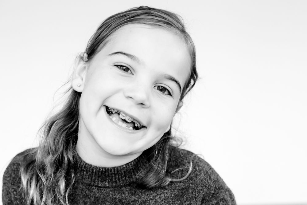 Child laughing while posing for a guided mini portrait in Northbrook