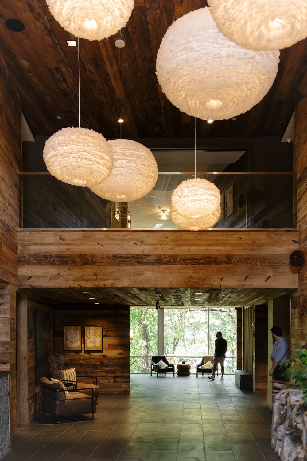 Modern rustic interior space with white paper lantern pendant lights hanging from wooden beamed ceiling.