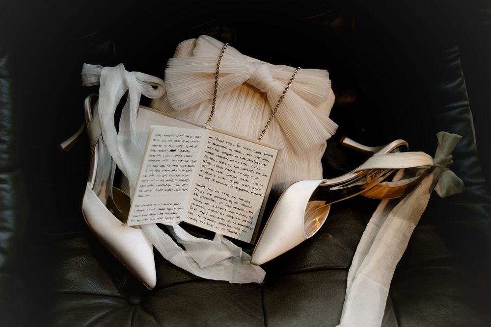 Vintage handwritten letters and papers scattered across a dark surface create a moody, nostalgic composition.