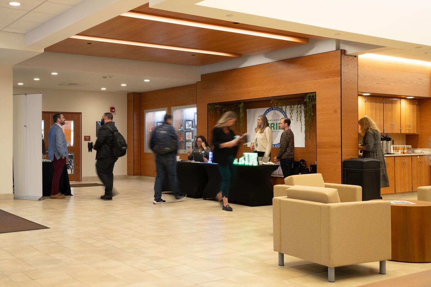 Modern office lobby with wood paneled walls, recessed lighting, and contemporary seating areas for visitors.